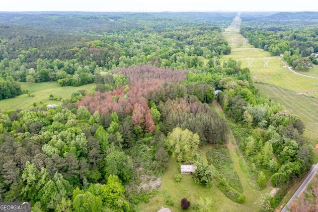aerial view of property and surrounding area featuring a heavily wooded area