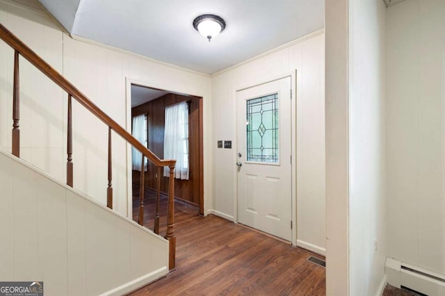 entrance foyer featuring a baseboard heating unit, wood finished floors, stairway, crown molding, and baseboards