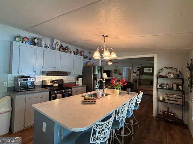 317 Cedar Dr NW, Sparta, GA 31087 - kitchen featuring appliances with stainless steel finishes, a sink, a chandelier, dark wood-style flooring, and a kitchen bar