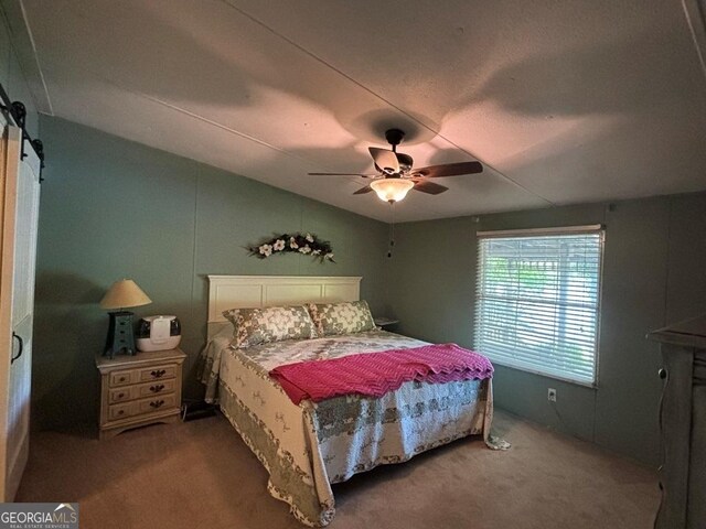317 Cedar Dr NW, Sparta, GA 31087 - bedroom with carpet flooring, a barn door, a ceiling fan, and lofted ceiling