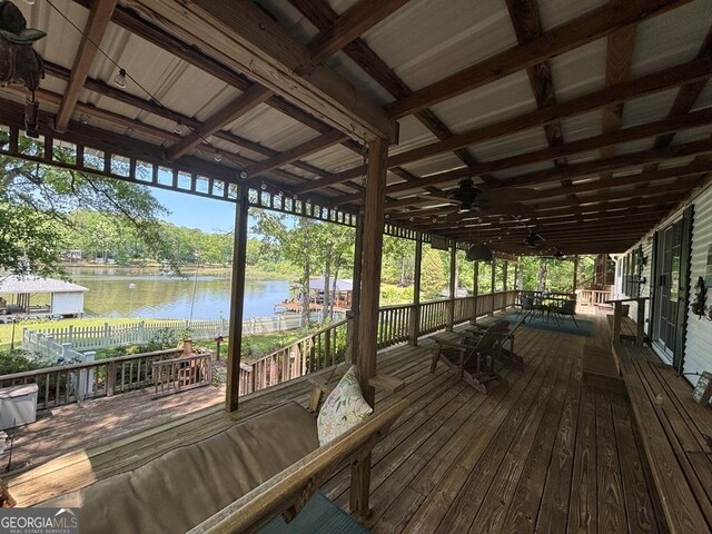 317 Cedar Dr NW, Sparta, GA 31087 - deck with a water view, fence, outdoor dining space, ceiling fan, and view of wooded area