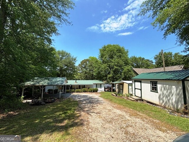 317 Cedar Dr NW, Sparta, GA 31087 - ranch-style home with driveway, metal roof, an outdoor structure, and a shed