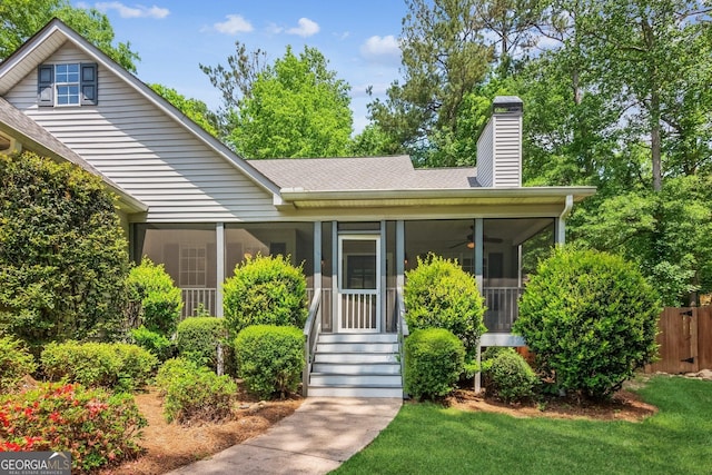 7675 Rose Ln, Cumming, GA 30040 - view of front of home with a sunroom, a chimney, a shingled roof, and ceiling fan