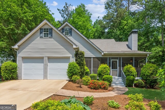 7675 Rose Ln, Cumming, GA 30040 - view of front of home with a sunroom, driveway, a garage, a shingled roof, and a chimney