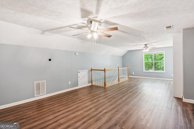 7675 Rose Ln, Cumming, GA 30040 - empty room with ceiling fan, a textured ceiling, wood finished floors, baseboards, and vaulted ceiling