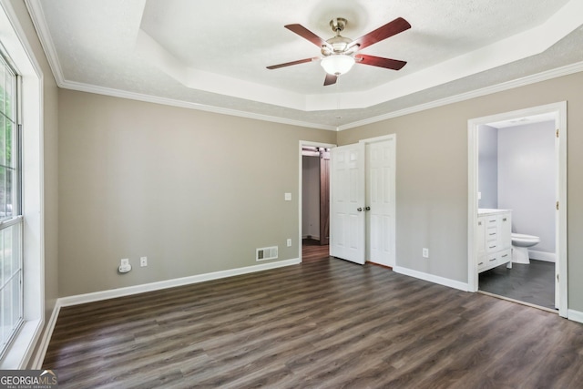 7675 Rose Ln, Cumming, GA 30040 - unfurnished bedroom featuring a tray ceiling, dark wood-style floors, ensuite bath, baseboards, and crown molding