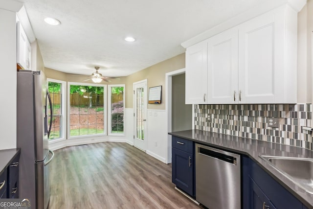 7675 Rose Ln, Cumming, GA 30040 - kitchen featuring appliances with stainless steel finishes, blue cabinets, ceiling fan, white cabinets, and light wood-style flooring