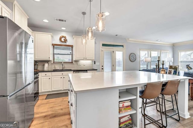 1903 Henderson Falls Way, Braselton, GA 30517 - kitchen featuring appliances with stainless steel finishes, a sink, a kitchen island, a kitchen bar, and light wood-style floors