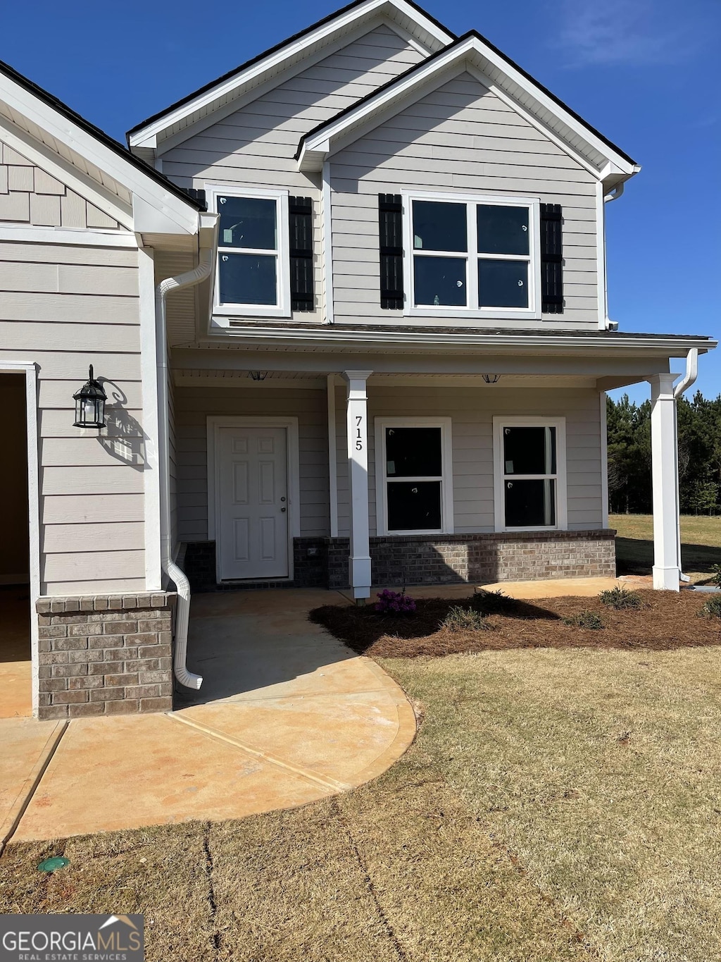 craftsman-style home with brick siding and covered porch