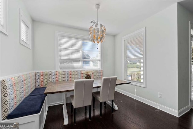 dining space with breakfast area, dark wood finished floors, a chandelier, and baseboards