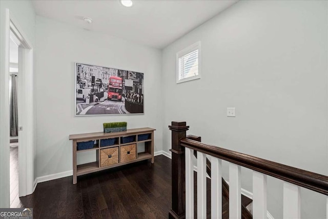 corridor featuring wood finished floors and baseboards