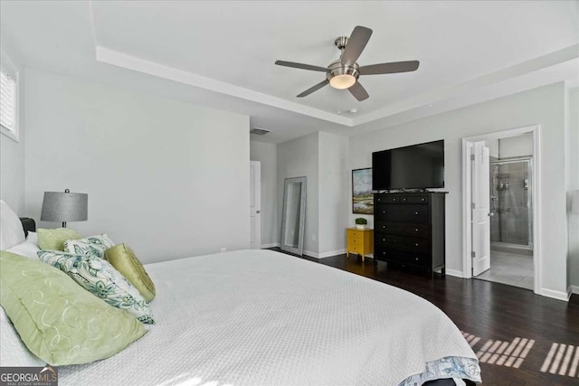 bedroom with a raised ceiling, wood finished floors, baseboards, and a ceiling fan