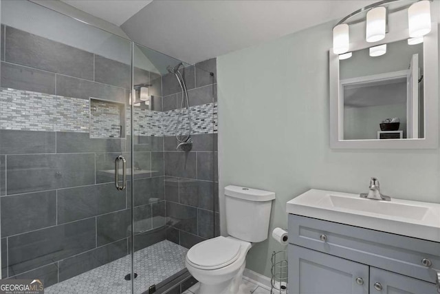 full bath with toilet, a shower stall, vanity, and baseboards