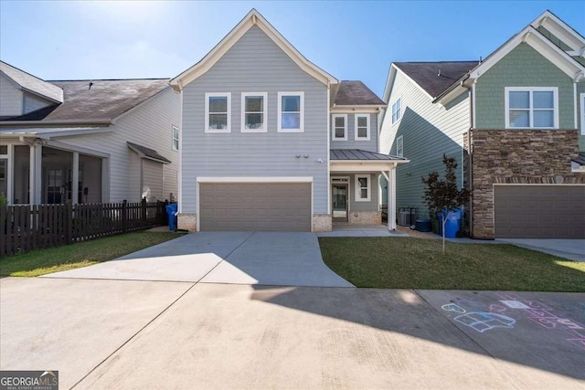view of front of property with a garage, concrete driveway, fence, a standing seam roof, and metal roof