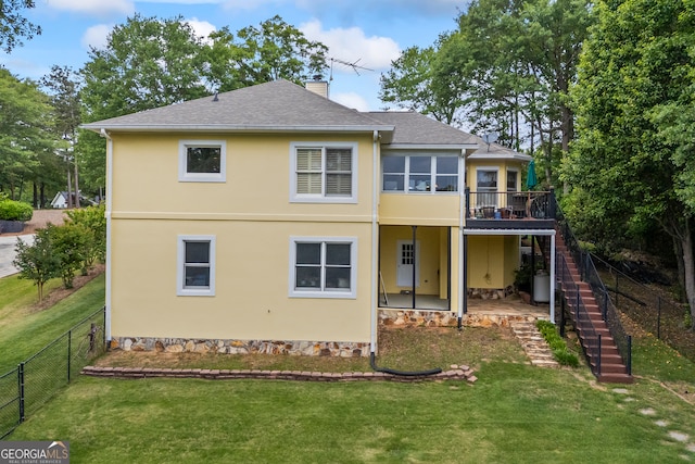 back of property featuring stairs, a chimney, stucco siding, a deck, and roof with shingles
