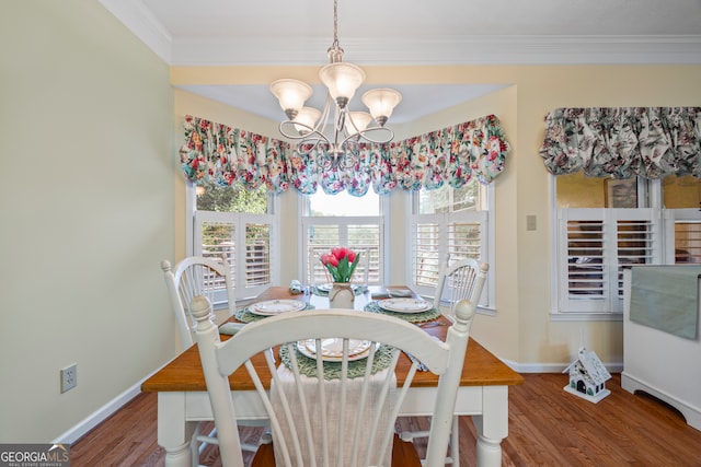 dining area with a chandelier, wood finished floors, baseboards, and crown molding