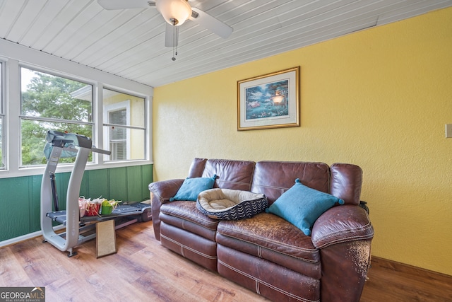 living room featuring wood finished floors, a ceiling fan, a textured wall, and wood ceiling