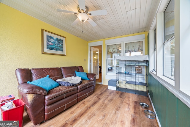 living room with wood finished floors, a ceiling fan, a textured wall, and wood ceiling