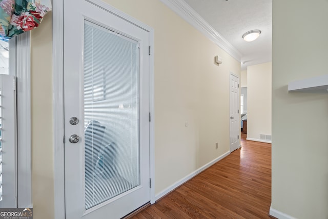 hallway with crown molding, wood finished floors, and baseboards