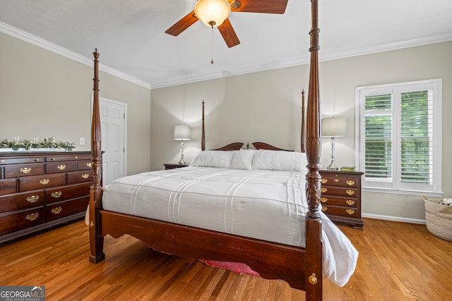 bedroom featuring wood finished floors, ornamental molding, baseboards, and ceiling fan