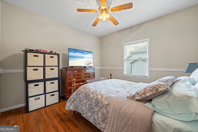 bedroom with wood finished floors, baseboards, and a ceiling fan