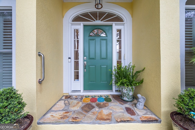 entrance to property featuring stucco siding