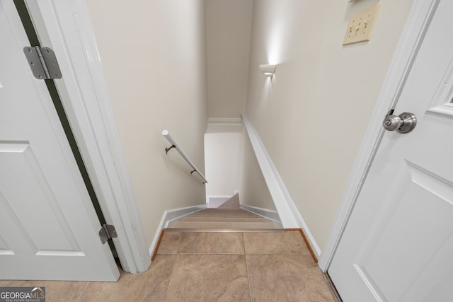 staircase featuring tile patterned floors and baseboards