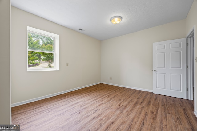 empty room featuring wood finished floors and baseboards