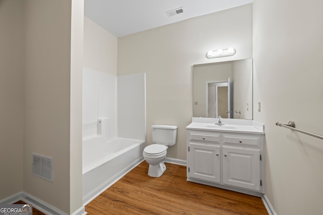 full bathroom with toilet, wood finished floors, vanity, baseboards, and bathtub / shower combination
