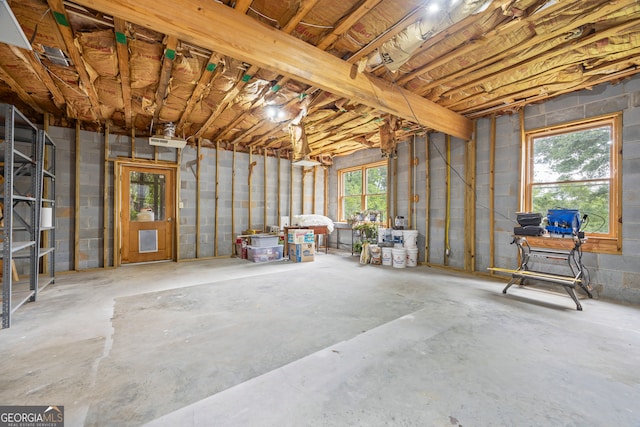 miscellaneous room with concrete flooring and concrete block wall