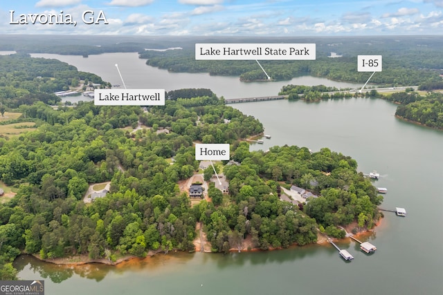 drone / aerial view of a nearby body of water and a forest