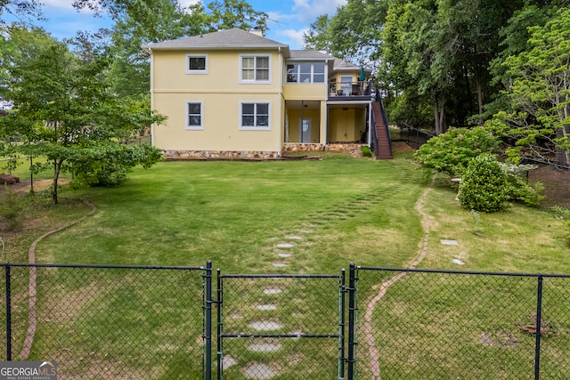 rear view of property with a gate, stairway, stucco siding, and a deck