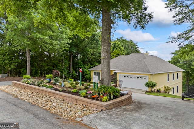 view of front of house featuring roof with shingles, driveway, and an attached garage