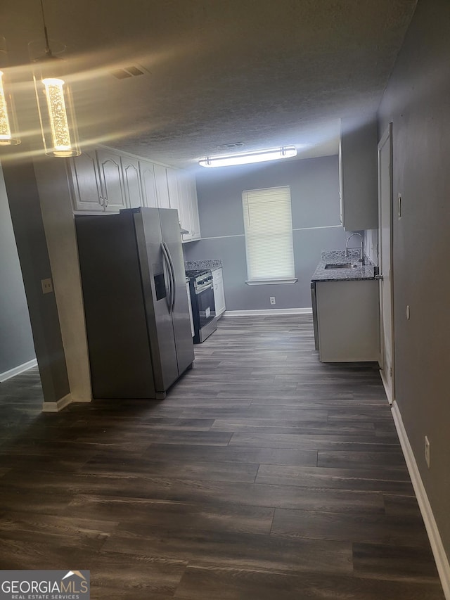 324 Cynthia Ct, Jonesboro, GA 30238 - kitchen featuring stainless steel appliances, baseboards, dark wood-type flooring, a sink, and white cabinets
