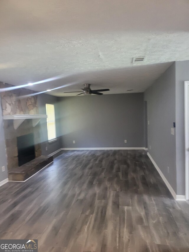 324 Cynthia Ct, Jonesboro, GA 30238 - unfurnished living room featuring a stone fireplace, ceiling fan, dark wood-style flooring, and baseboards