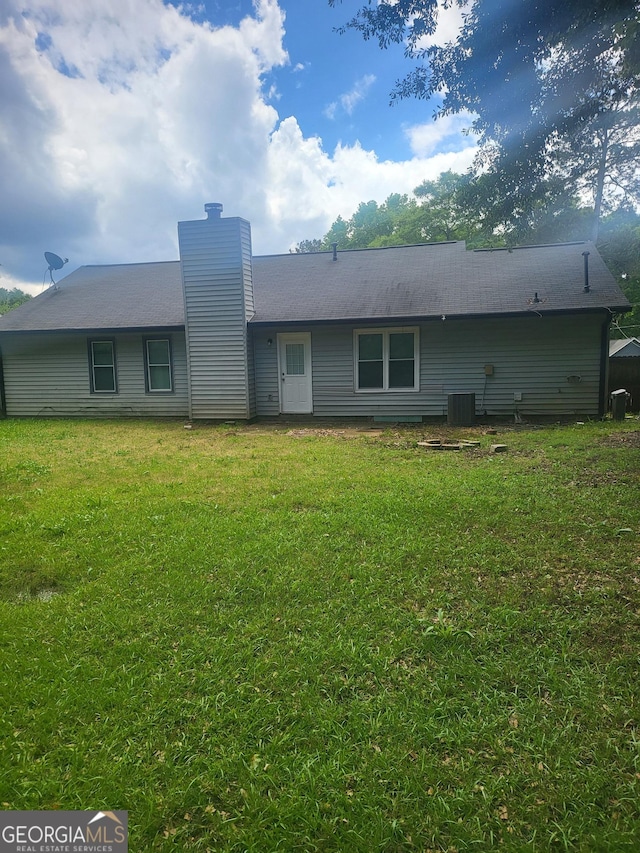 324 Cynthia Ct, Jonesboro, GA 30238 - rear view of house with a chimney, a yard, and central AC