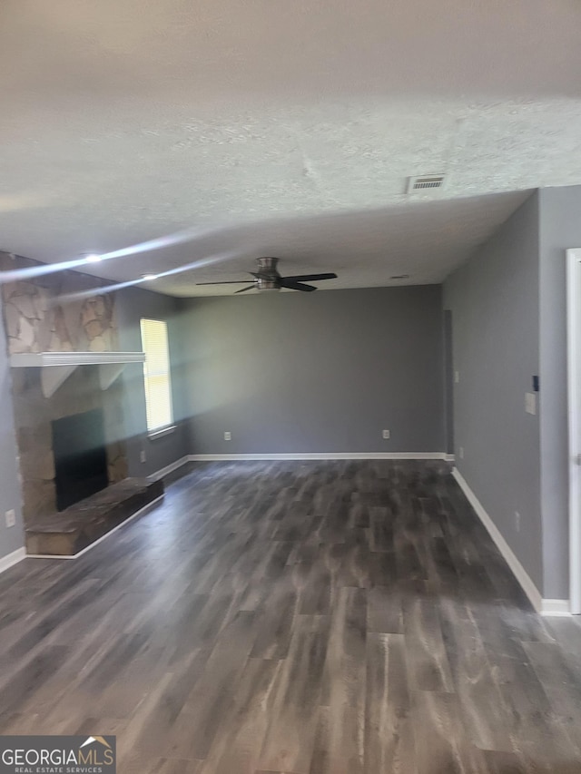 324 Cynthia Ct, Jonesboro, GA 30238 - unfurnished living room featuring a stone fireplace, ceiling fan, dark wood-style flooring, and baseboards