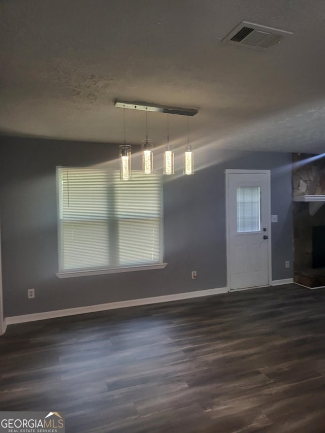324 Cynthia Ct, Jonesboro, GA 30238 - unfurnished dining area with dark wood-style flooring, baseboards, and a textured ceiling