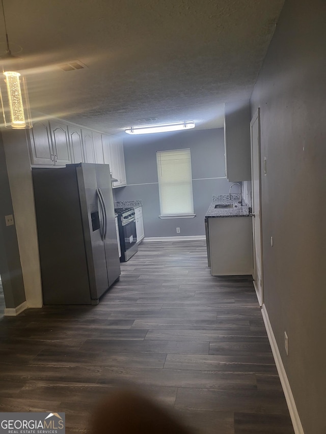 324 Cynthia Ct, Jonesboro, GA 30238 - kitchen with appliances with stainless steel finishes, baseboards, dark wood-style floors, a sink, and a textured ceiling