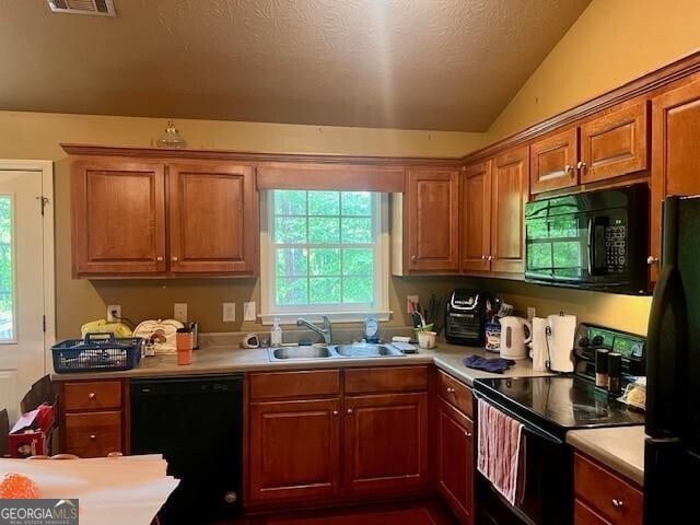 118 High Ridge Ln, Dahlonega, GA 30533 - kitchen with black appliances, a sink, lofted ceiling, light countertops, and brown cabinets
