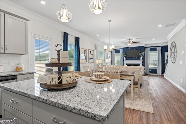 kitchen with gray cabinetry, ceiling fan, plenty of natural light, ornamental molding, and dark wood finished floors