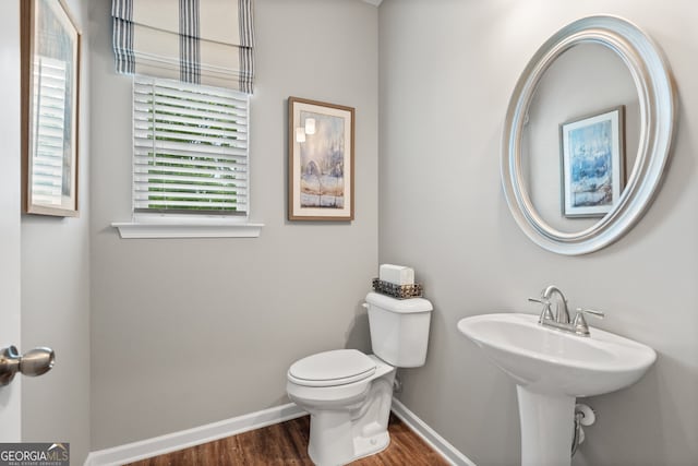 bathroom with wood finished floors, toilet, and baseboards