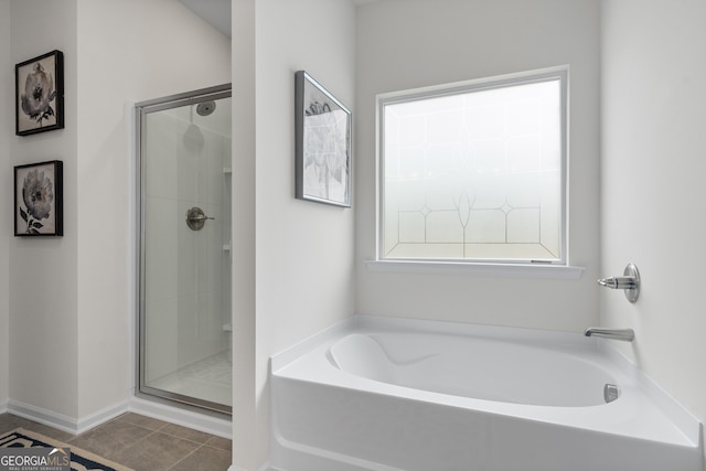 bathroom with a stall shower, a garden tub, and tile patterned flooring