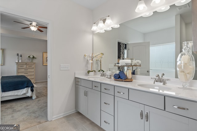 ensuite bathroom with ceiling fan, double vanity, baseboards, and tile patterned flooring