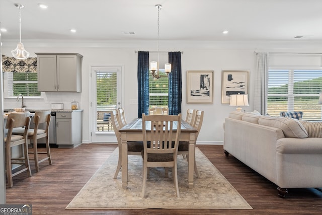 dining room featuring crown molding, a chandelier, baseboards, dark wood finished floors, and recessed lighting