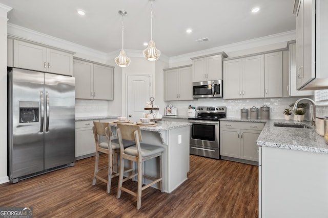 kitchen featuring stainless steel appliances, gray cabinetry, a sink, decorative backsplash, and ornamental molding