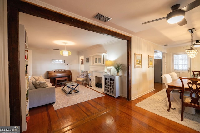 309 Mahan St, Saint Marys, GA 31558 - living area featuring a ceiling fan, ornamental molding, wood finished floors, and a chandelier