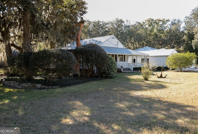 309 Mahan St, Saint Marys, GA 31558 - rear view of house featuring covered porch, a yard, and metal roof