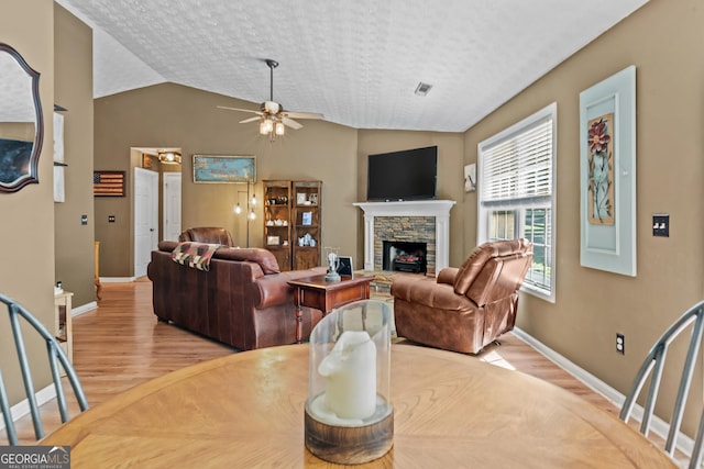 108 Wortham Dr, Buckhead, GA 30625 - living room featuring wood finished floors, ceiling fan, a stone fireplace, baseboards, and vaulted ceiling