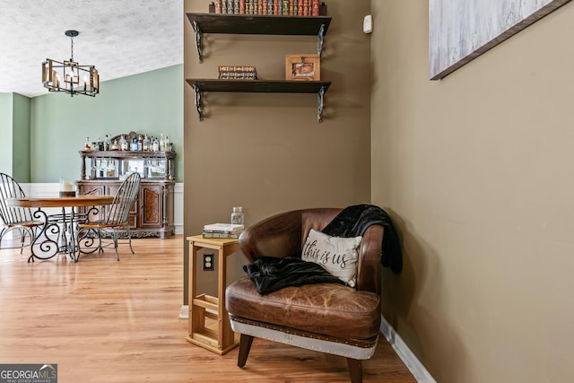 108 Wortham Dr, Buckhead, GA 30625 - living area featuring wood finished floors, a chandelier, a textured ceiling, and baseboards